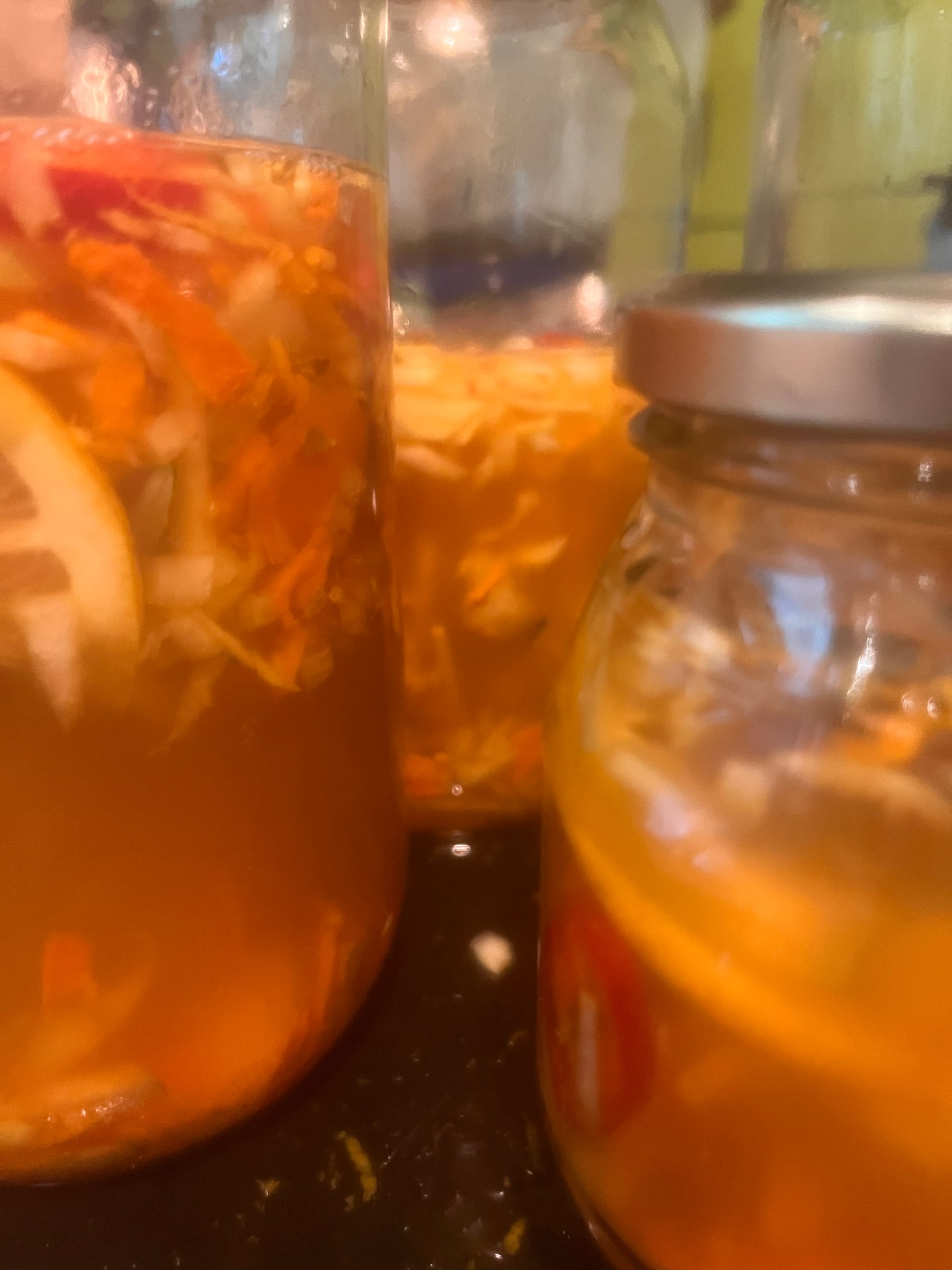brightest orange jars of fire cider: chopped ingredients in apple vinegar